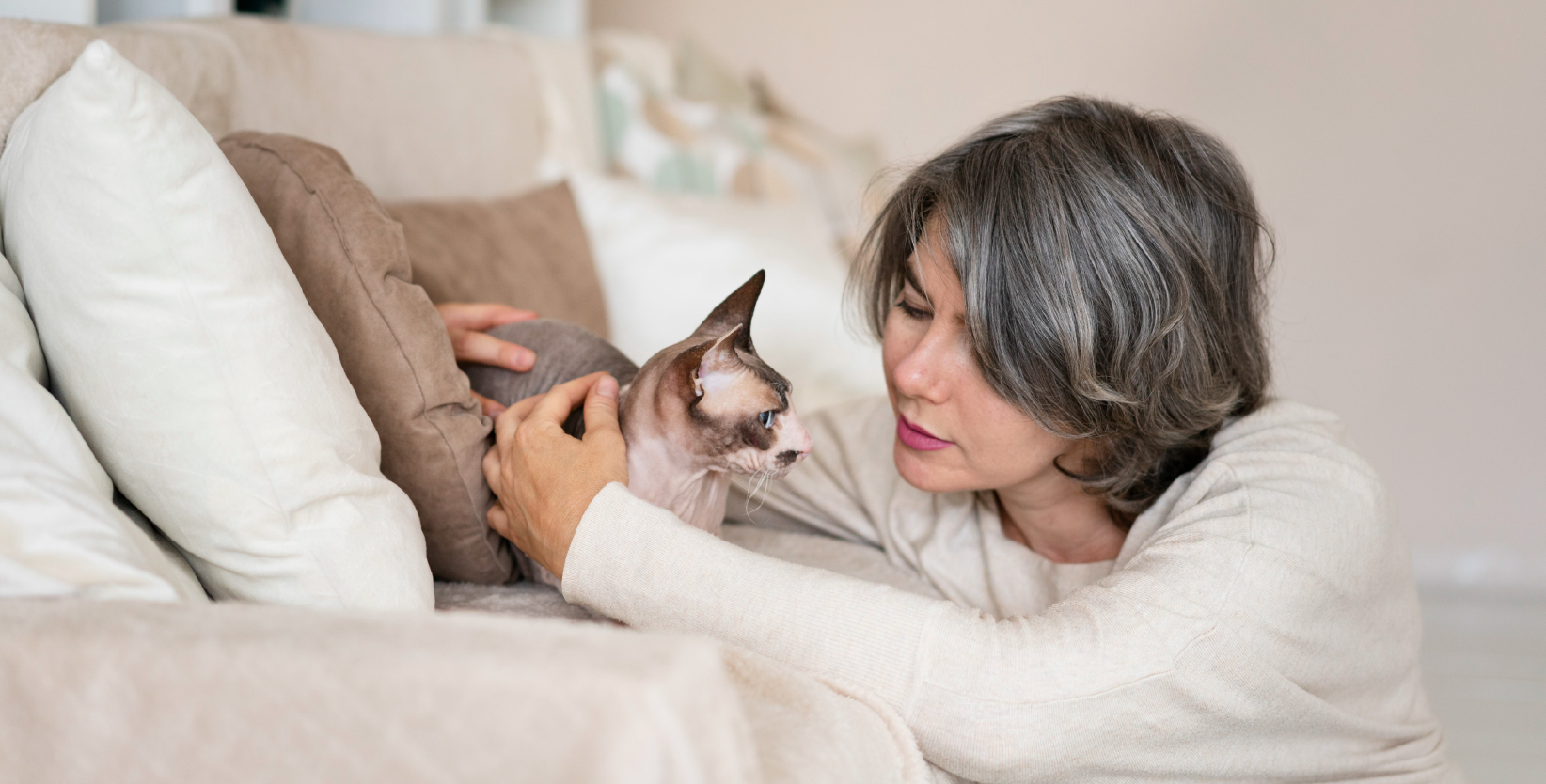 Eine Frau streichelt eine Katze trotz Katzenallergie.
