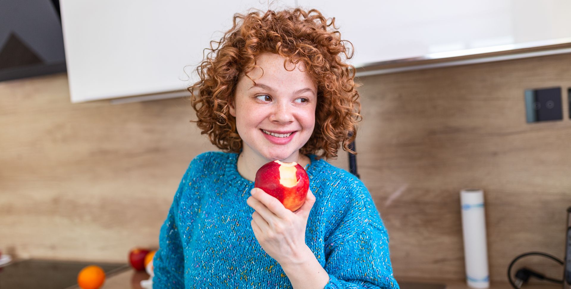 Eine Frau mit Apfel, der Cholesterin mit der Ernährung senken kann.