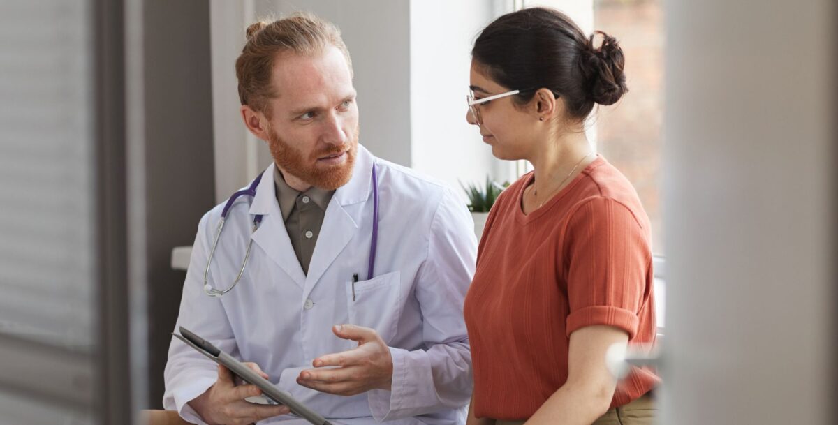 Ein Arzt erklärt einer Patientin Ihre Cholesterin-Werte mit dem HDL-LDL-Quotient.
