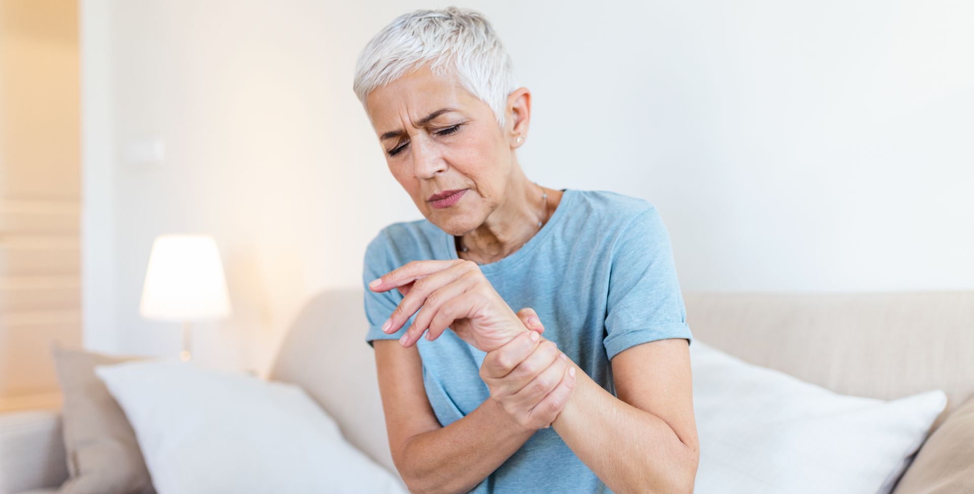 Eine Frau hält sich den Arm, denn Gelenkschmerzen können ein Symptom einer Entzündung im Körper sein.