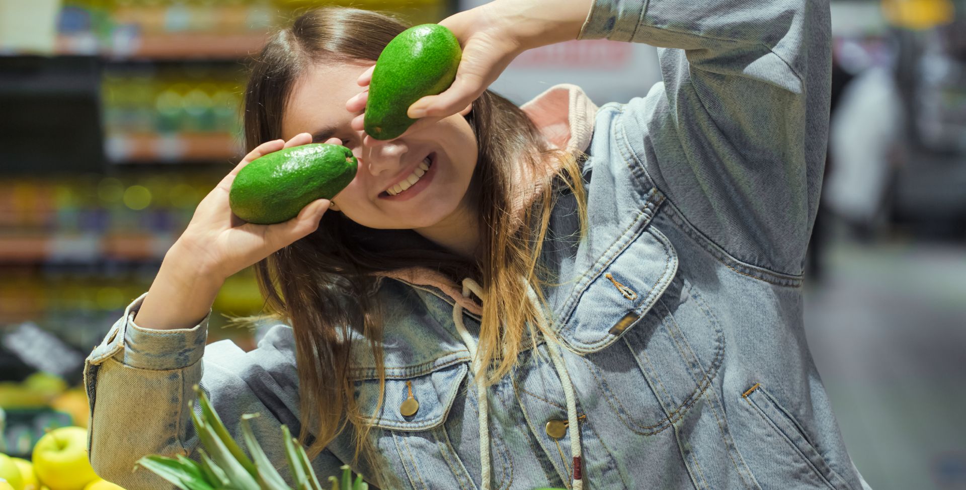 Eine Frau hält sich Avocados mit Vitamin E vor die Augen.