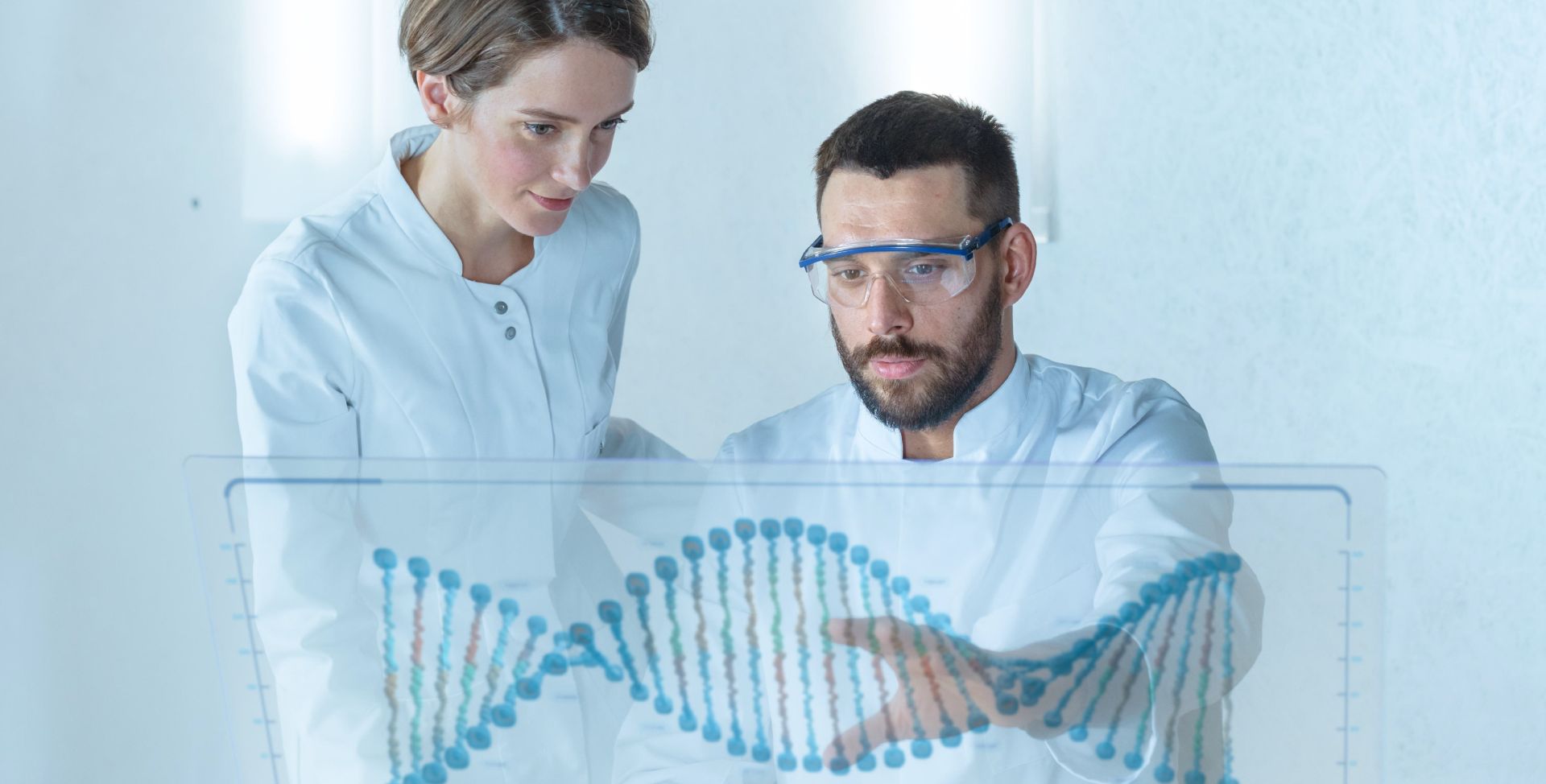 Zwei Wissenschaftler betrachten ein Modell des DNA-Aufbaus in der Doppelhelix.