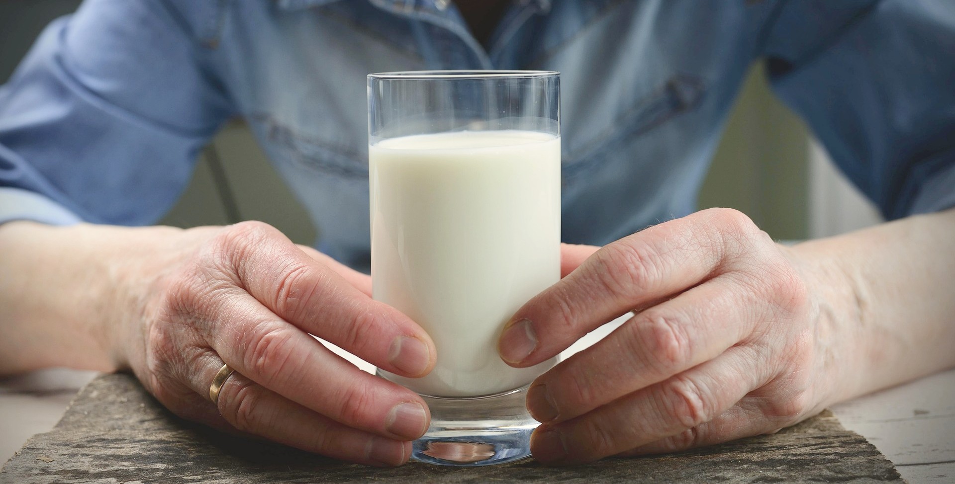 Ein Mann mit einem Glas Milch, das mit Laktoseintoleranz zum Problem werden kann.