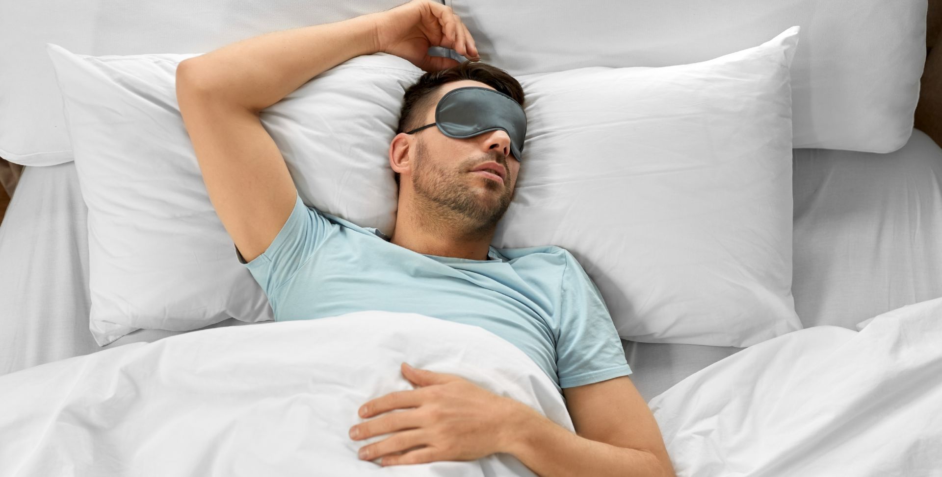 Ein Mann schläft mit Maske im hellen Zimmer, eher den Schlaftypen Eule als Lerche entsprechend.