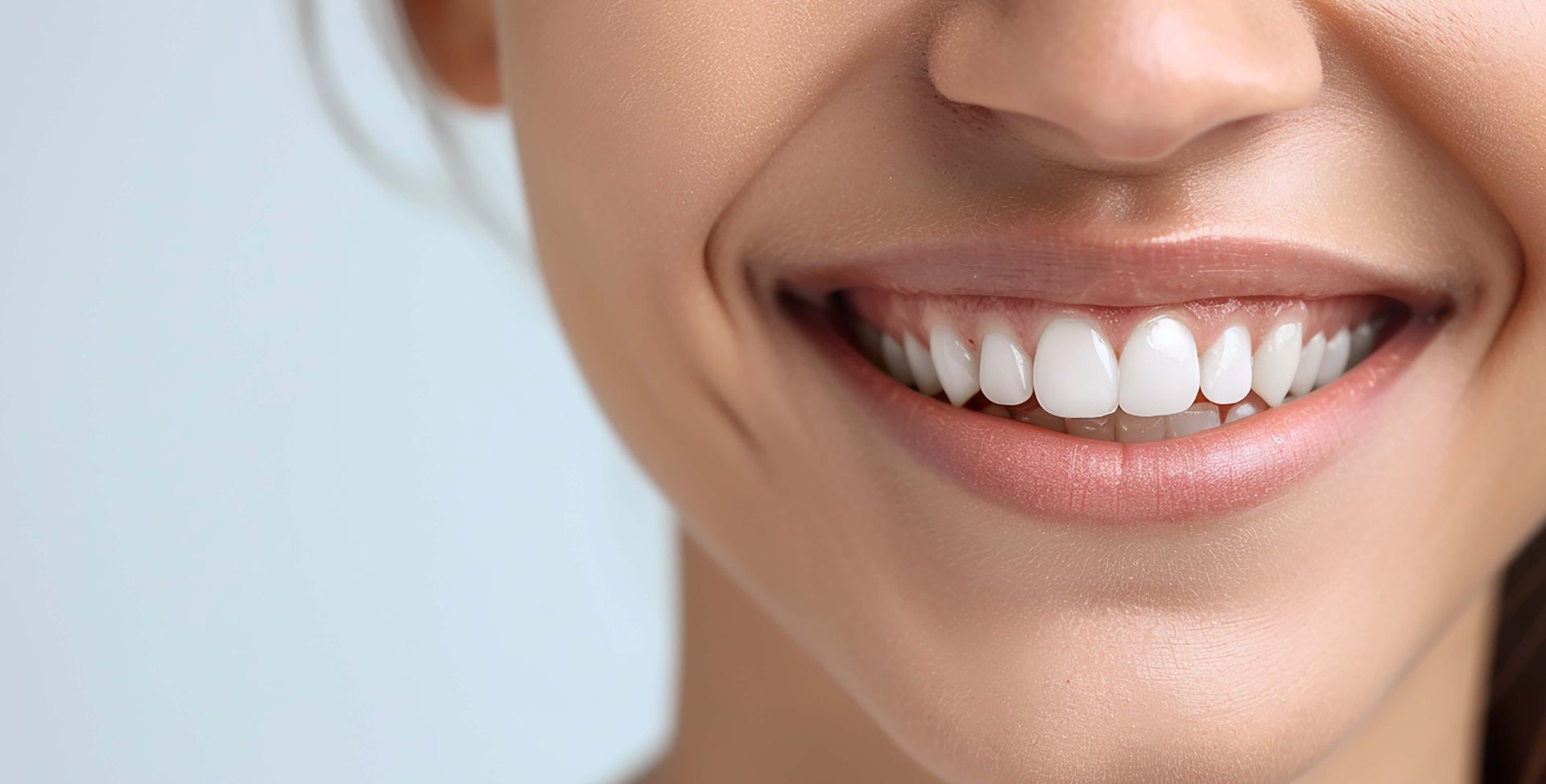 Eine Frau mit weißen Zähnen lächelt – auch dank ihrer Genetik.