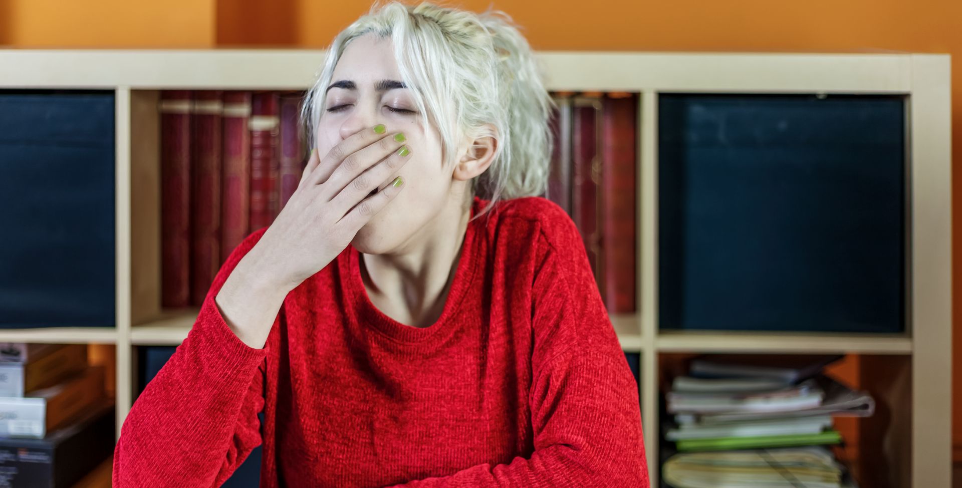 Eine Frau gähnt, weil der Spiegel an Cortisol niedrig ist.