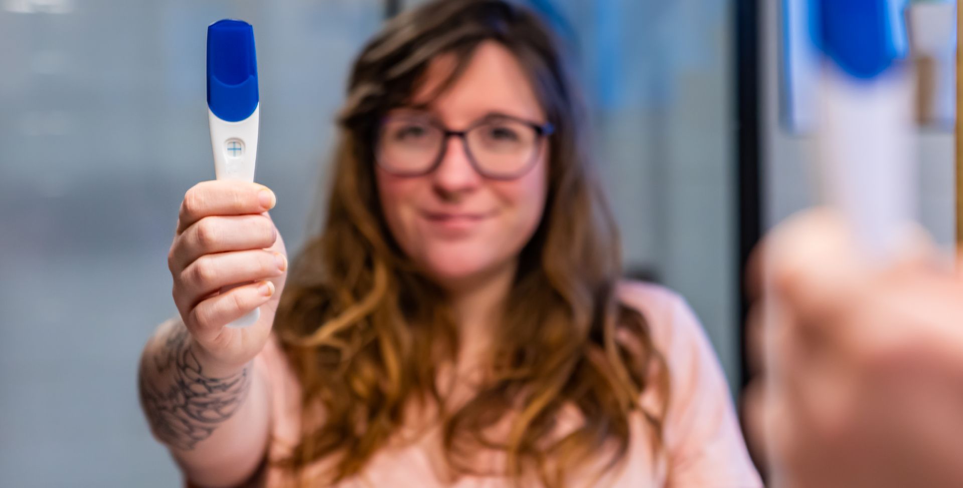 Eine Frau mit Schwangerschaftstest als Sinnbild fürs Hormon Progesteron.