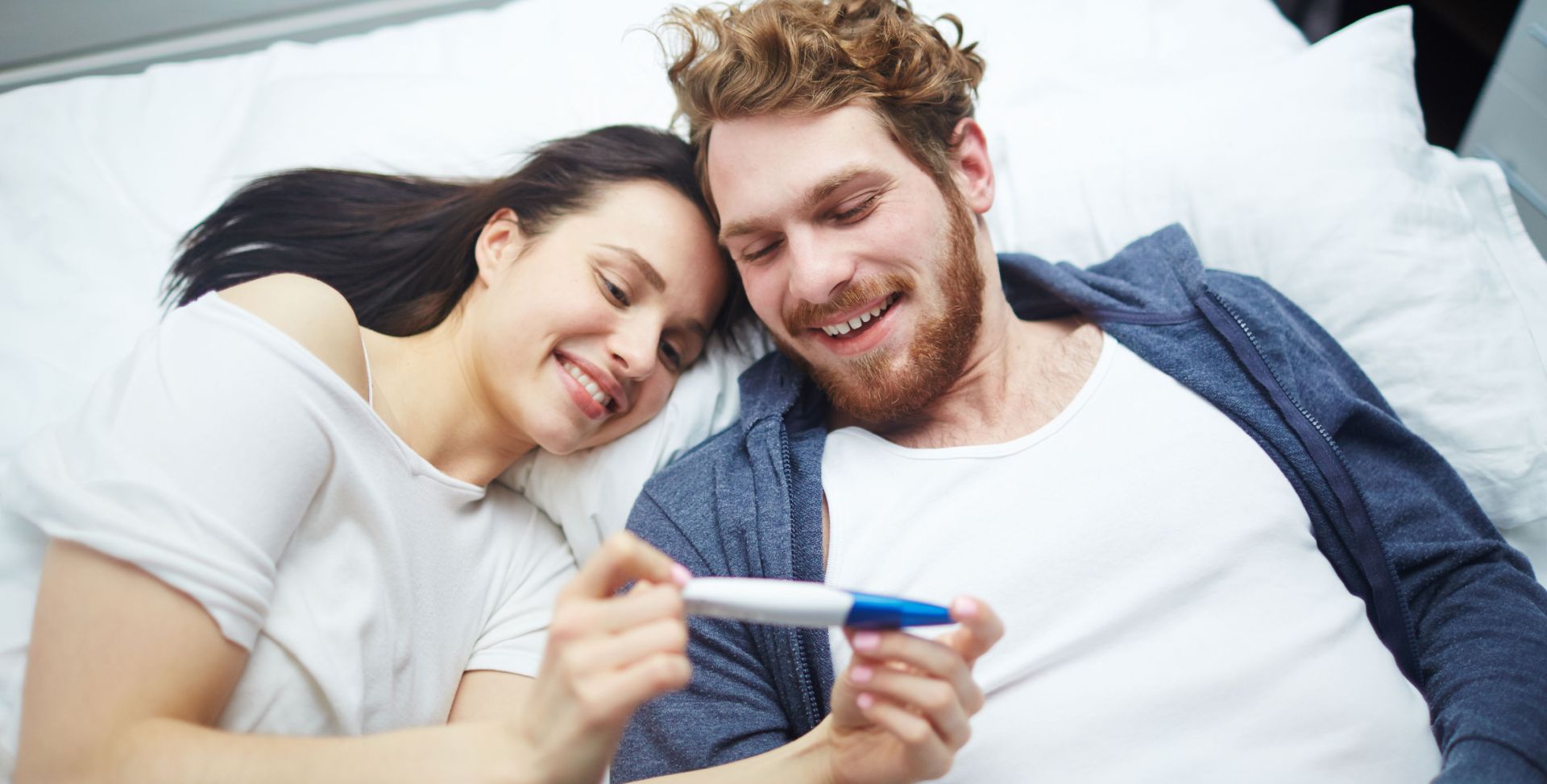 Ein Paar schaut auf einen Schwangerschaftstest. Sinnbild für das Anti-Müller-Hormon.