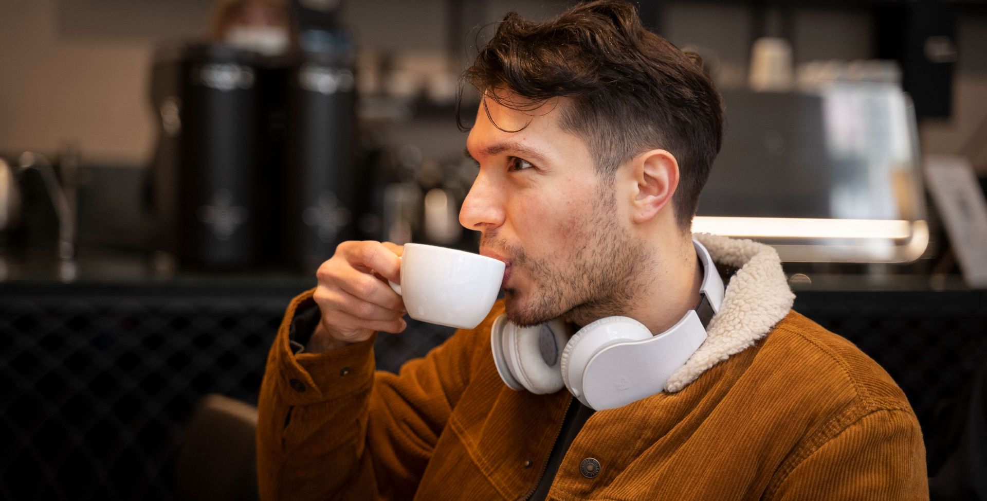 Ein junger Mann trinkt eine Tasse Kaffee. Sinnbild für Kaffee-Unverträglichkeit.