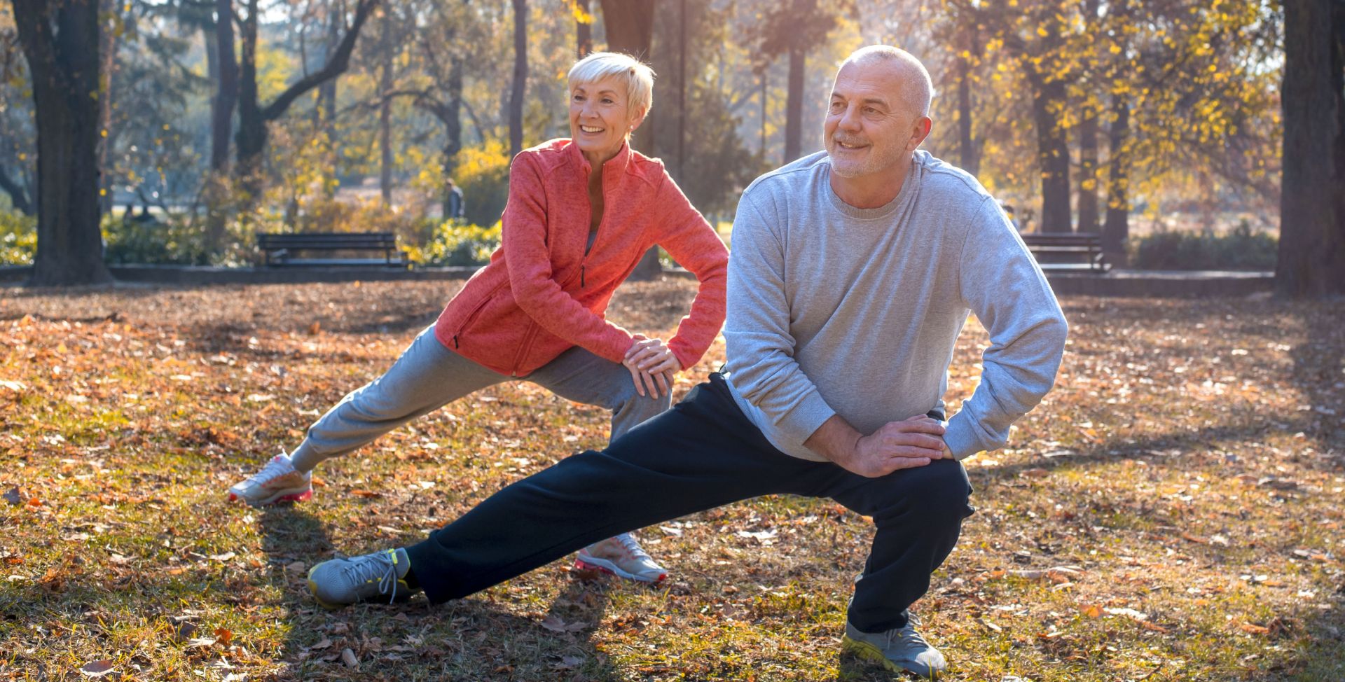 Zwei ältere Erwachsene beim Sport im Park, der auch die mentale Fitness fördert.
