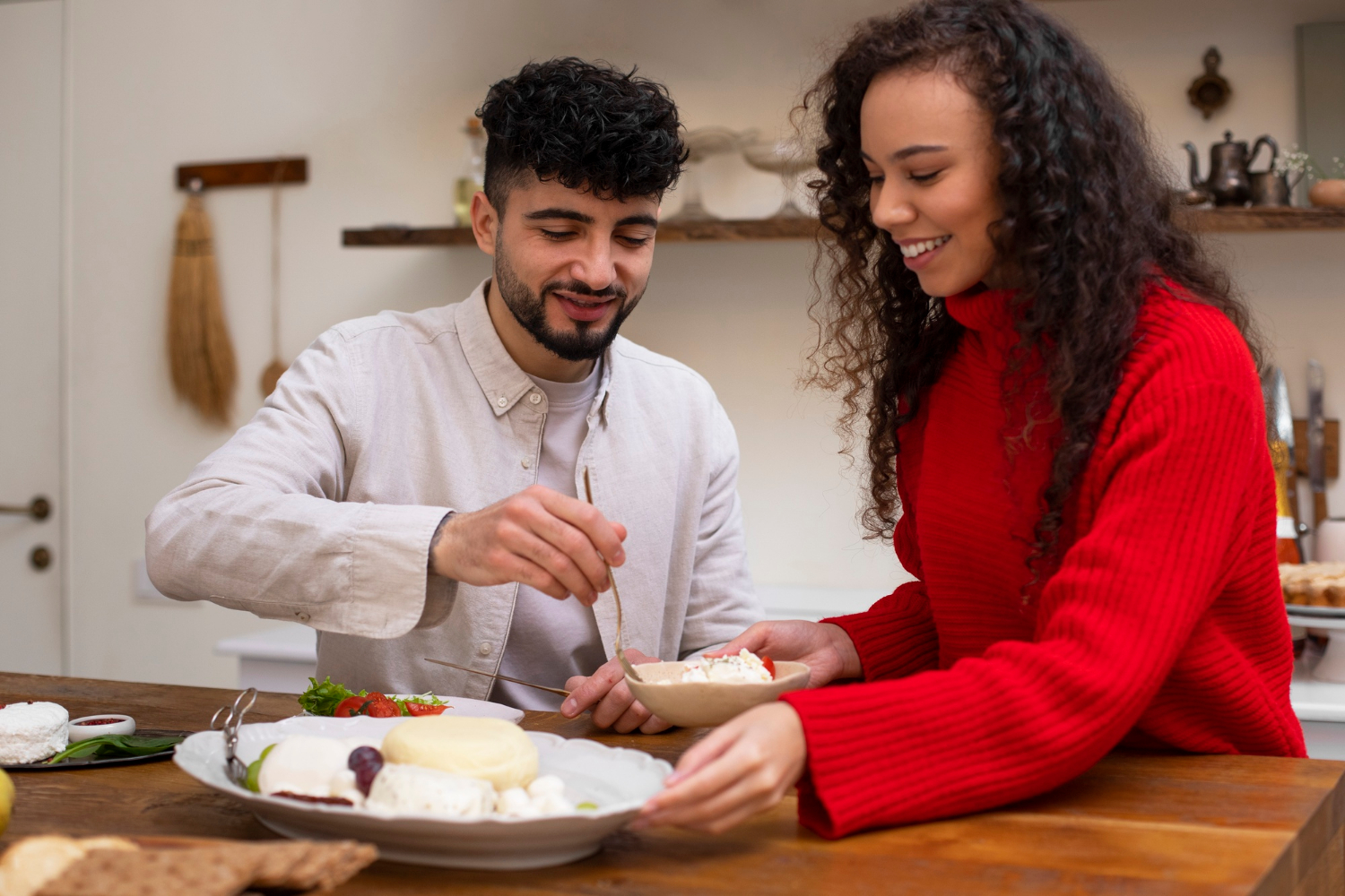 Zwei Menschen bereiten eine Käseplatte als Teil der vegetarischen Ernährung vor.