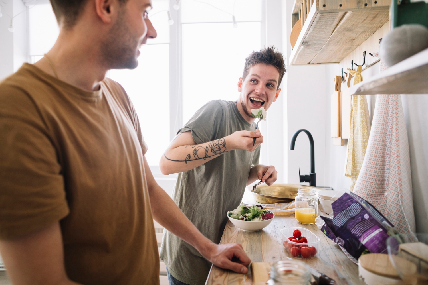 Zwei Männer bereiten eine gesunde Mahlzeit im Rahmen einer Ernährungsumstellung zu.