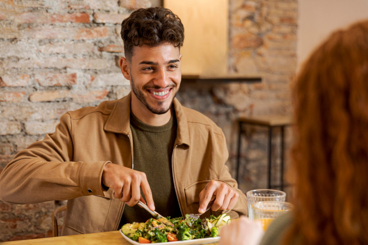 Ein Mann isst von einem Teller mit pflanzlicher Nahrung. Sinnbild für die vegane Ernährung.